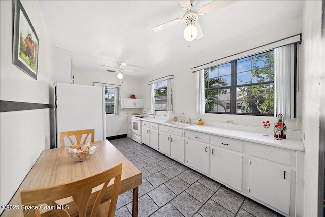 415 2nd Ave, Indialantic, FL 32903 - kitchen with white appliances, a ceiling fan, white cabinets, light countertops, and light stone finish floors