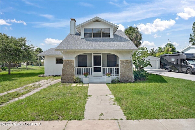 415 2nd Ave, Indialantic, FL 32903 - bungalow-style home featuring stone siding, covered porch, a chimney, a front lawn, and an outdoor structure