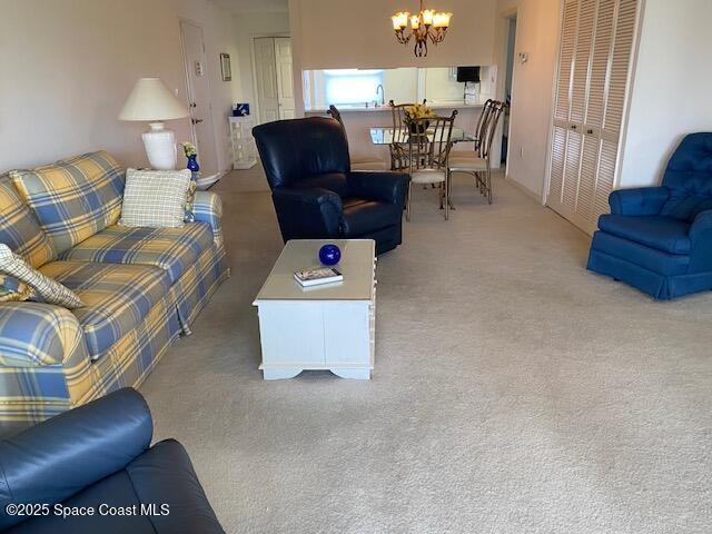 2727 N Wickham Rd # 106-7, Melbourne, FL 32935 - carpeted living room featuring a chandelier