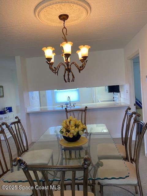 2727 N Wickham Rd # 106-7, Melbourne, FL 32935 - carpeted dining space featuring a chandelier and a textured ceiling