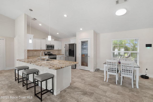1036 Greenleaf Ct, Rockledge, FL 32955 - kitchen with appliances with stainless steel finishes, lofted ceiling, a peninsula, a kitchen bar, and tasteful backsplash