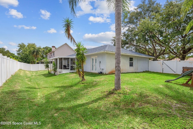 1036 Greenleaf Ct, Rockledge, FL 32955 - back of property with a sunroom, a fenced backyard, stucco siding, and a gate