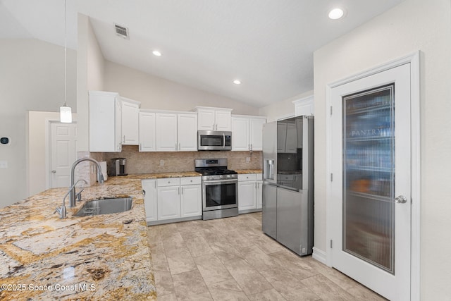 1036 Greenleaf Ct, Rockledge, FL 32955 - kitchen featuring appliances with stainless steel finishes, lofted ceiling, backsplash, white cabinets, and light stone counters