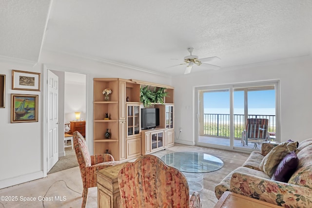 3170 N Atlantic Ave N Unit 403, Cocoa Beach, FL 32931 - living area featuring ornamental molding, ceiling fan, and a textured ceiling