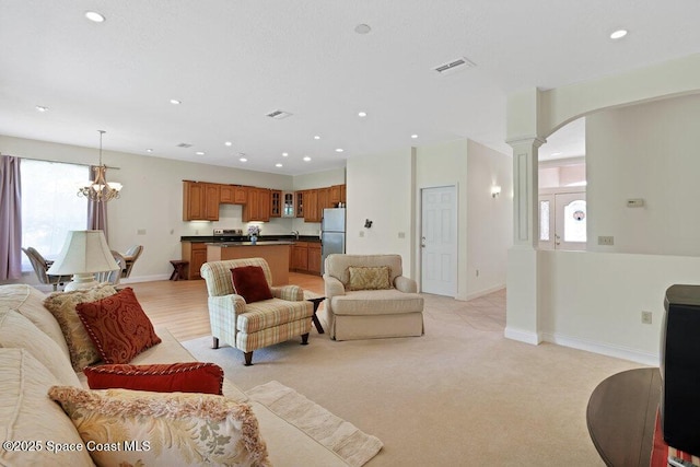 3825 Allen Ave, Micco, FL 32976 - living area with arched walkways, recessed lighting, decorative columns, a chandelier, and light carpet