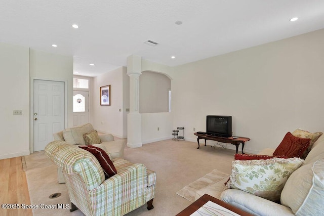 3825 Allen Ave, Micco, FL 32976 - living area featuring arched walkways, recessed lighting, decorative columns, and light colored carpet