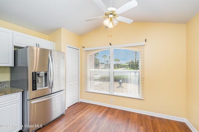 1713 Keys Gate Dr, Melbourne, FL 32940 - kitchen with stainless steel refrigerator with ice dispenser, light wood finished floors, white cabinetry, vaulted ceiling, and a ceiling fan