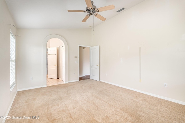 1713 Keys Gate Dr, Melbourne, FL 32940 - empty room with arched walkways, light colored carpet, ceiling fan, and high vaulted ceiling
