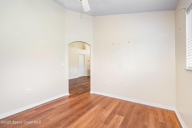 1713 Keys Gate Dr, Melbourne, FL 32940 - empty room with arched walkways, a ceiling fan, and light wood-style floors