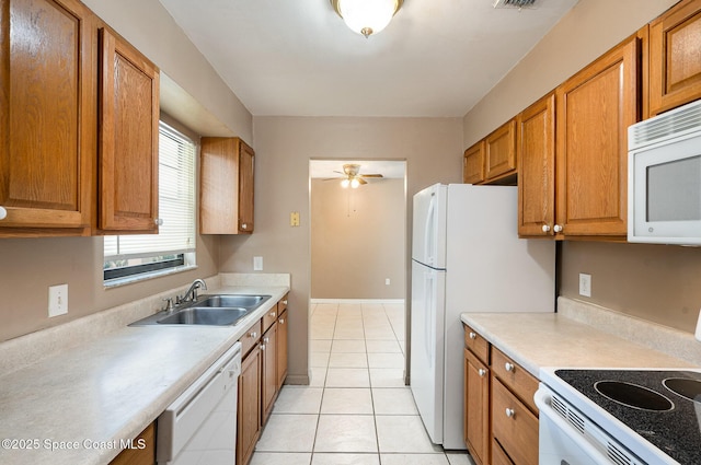 2234 Flower Tree Cir, Melbourne, FL 32935 - kitchen with white appliances, brown cabinetry, light countertops, and light tile patterned floors