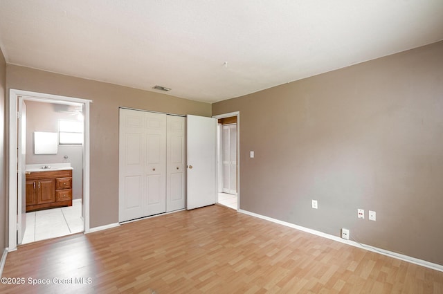 2234 Flower Tree Cir, Melbourne, FL 32935 - unfurnished bedroom with light wood-type flooring, a closet, and ensuite bathroom