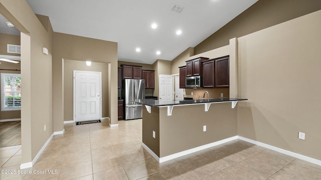 1448 Attilburgh Blvd, West Melbourne, FL 32904 - kitchen with stainless steel appliances, a kitchen bar, a peninsula, dark countertops, and dark brown cabinetry