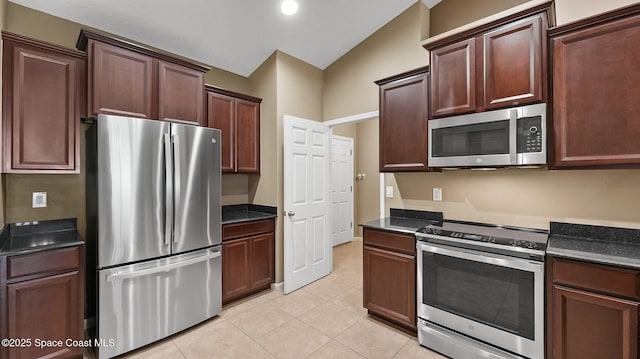1448 Attilburgh Blvd, West Melbourne, FL 32904 - kitchen featuring stainless steel appliances, dark countertops, light tile patterned floors, dark brown cabinets, and vaulted ceiling