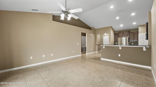 1448 Attilburgh Blvd, West Melbourne, FL 32904 - kitchen featuring freestanding refrigerator, a ceiling fan, a kitchen breakfast bar, light tile patterned flooring, and vaulted ceiling