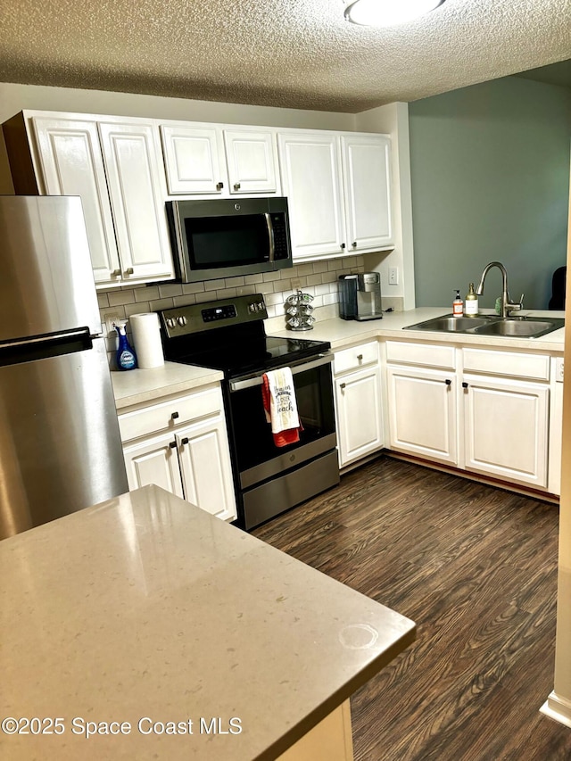 1070 Bella Vista Blvd Unit 110, Saint Augustine, FL 32084 - kitchen featuring appliances with stainless steel finishes, dark wood-style flooring, backsplash, and a textured ceiling