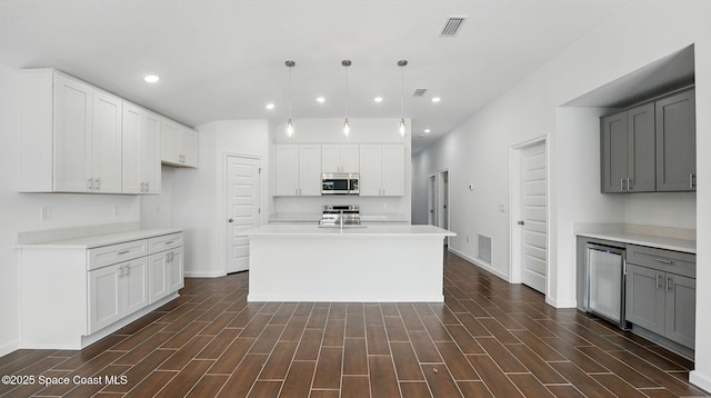 298 Wendover Rd SW, Palm Bay, FL 32908 - kitchen with stainless steel appliances, recessed lighting, beverage cooler, light countertops, and white cabinets