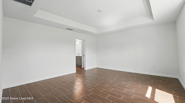 298 Wendover Rd SW, Palm Bay, FL 32908 - empty room featuring a tray ceiling and dark wood-style flooring