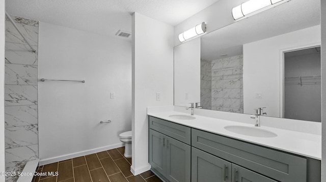 298 Wendover Rd SW, Palm Bay, FL 32908 - bathroom with double vanity, a marble finish shower, a spacious closet, marble look tile flooring, and a textured ceiling