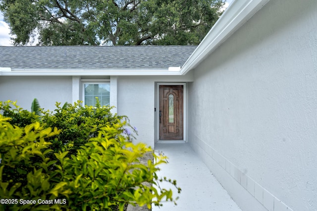 1249 Coosa Ave NE, Palm Bay, FL 32907 - property entrance with stucco siding and a shingled roof