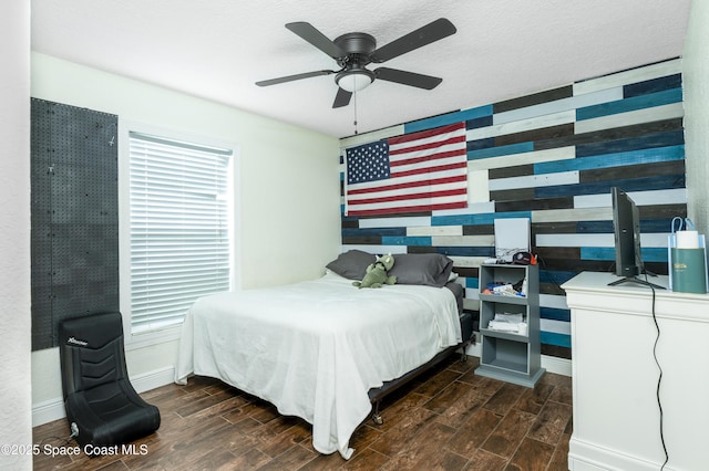 1249 Coosa Ave NE, Palm Bay, FL 32907 - bedroom featuring wood finished floors, wooden walls, a ceiling fan, and an accent wall
