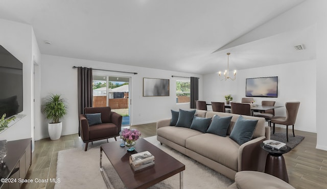 667 Tarr Ave SW, Palm Bay, FL 32908 - living area featuring a chandelier, light wood-type flooring, and vaulted ceiling
