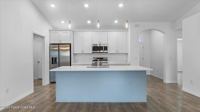 667 Tarr Ave SW, Palm Bay, FL 32908 - kitchen featuring appliances with stainless steel finishes, arched walkways, an island with sink, light countertops, and white cabinets