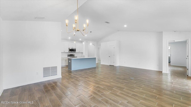667 Tarr Ave SW, Palm Bay, FL 32908 - unfurnished living room featuring a chandelier, lofted ceiling, light wood finished floors, and recessed lighting