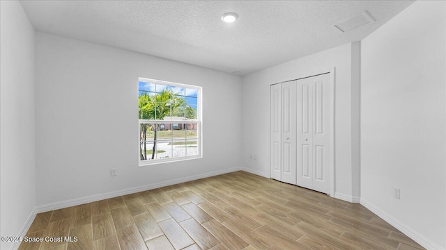 667 Tarr Ave SW, Palm Bay, FL 32908 - unfurnished bedroom featuring light wood-type flooring, a textured ceiling, a closet, and attic access
