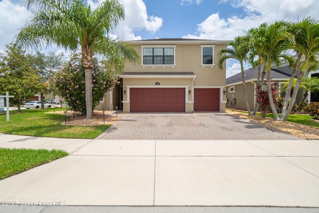 1026 Shiloh Dr, Melbourne, FL 32940 - view of front of home featuring an attached garage, decorative driveway, stucco siding, and a front lawn