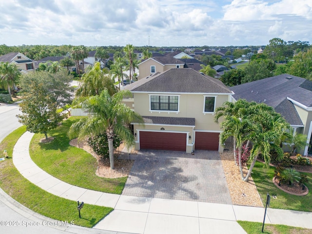 1026 Shiloh Dr, Melbourne, FL 32940 - view of front of house with an attached garage, roof with shingles, decorative driveway, and a residential view