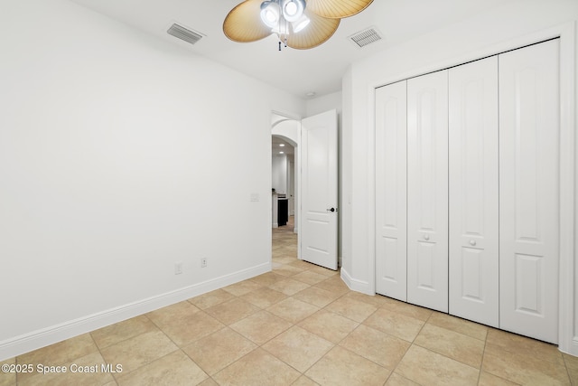 1026 Shiloh Dr, Melbourne, FL 32940 - unfurnished bedroom with arched walkways, light tile patterned flooring, a closet, and ceiling fan
