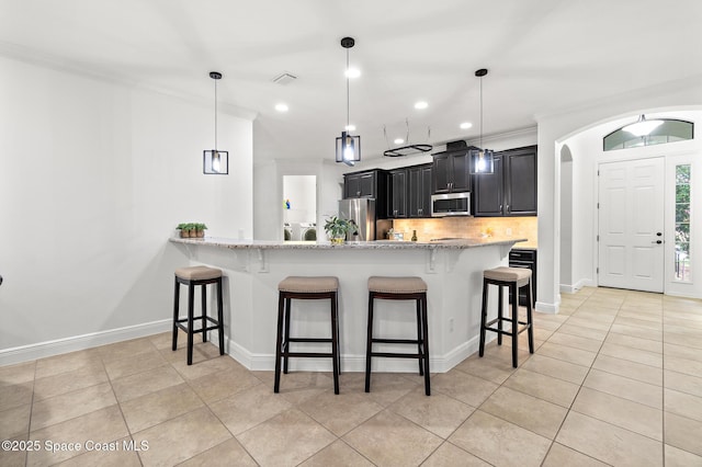 1026 Shiloh Dr, Melbourne, FL 32940 - kitchen featuring stainless steel appliances, dark cabinets, a kitchen bar, recessed lighting, and backsplash