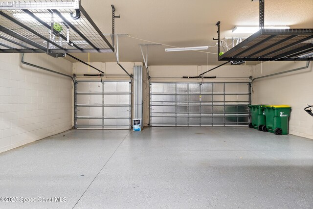 1026 Shiloh Dr, Melbourne, FL 32940 - garage featuring concrete block wall and a garage door opener