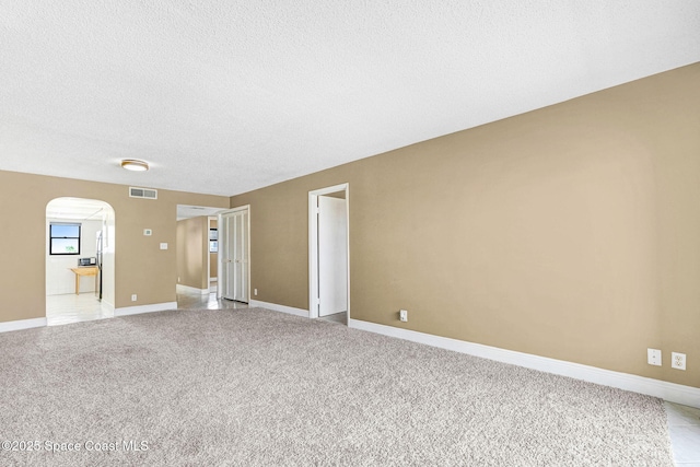 520 Palm Springs Blvd Unit 405, Indian Harbour Beach, FL 32937 - unfurnished room featuring arched walkways, light colored carpet, and a textured ceiling