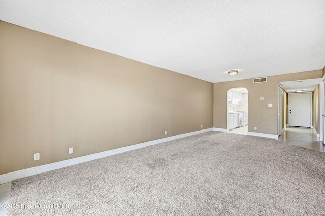520 Palm Springs Blvd Unit 405, Indian Harbour Beach, FL 32937 - unfurnished room with arched walkways, light carpet, and a textured ceiling