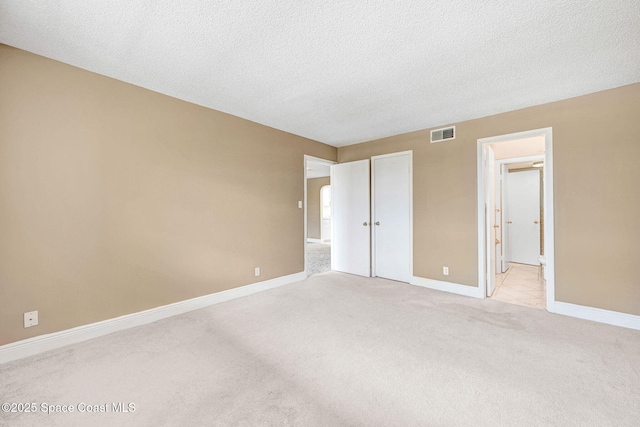 520 Palm Springs Blvd Unit 405, Indian Harbour Beach, FL 32937 - unfurnished bedroom featuring light colored carpet, a textured ceiling, and ensuite bathroom