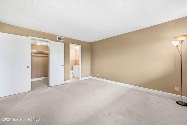 520 Palm Springs Blvd Unit 405, Indian Harbour Beach, FL 32937 - unfurnished bedroom with light colored carpet, a spacious closet, a closet, a textured ceiling, and ensuite bathroom