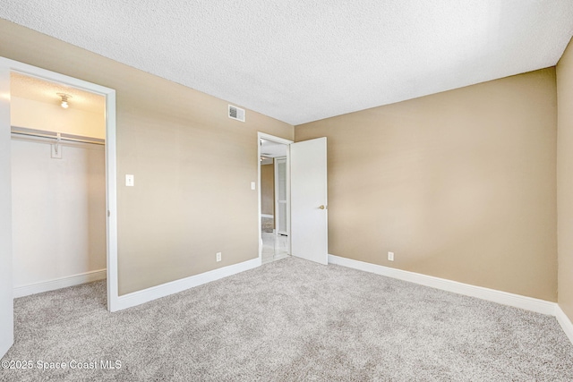 520 Palm Springs Blvd Unit 405, Indian Harbour Beach, FL 32937 - unfurnished bedroom with carpet, a textured ceiling, a closet, and a spacious closet