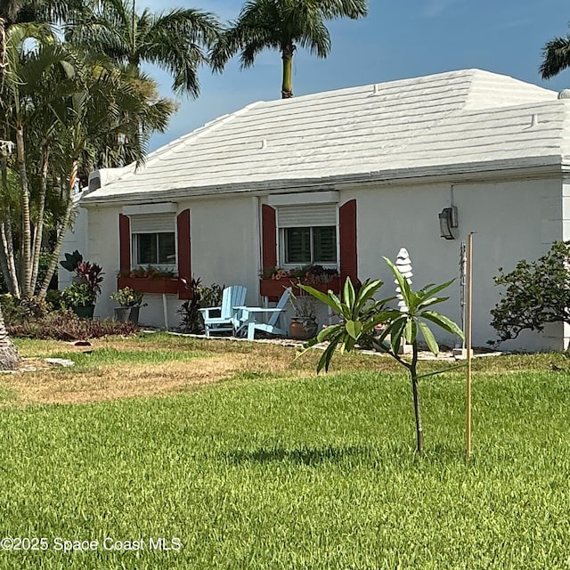 55 Country Club Rd, Cocoa Beach, FL 32931 - view of front of home with a front lawn and stucco siding