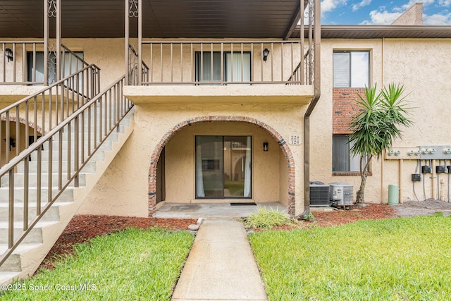 128 San Paulo Cir Unit 128, West Melbourne, FL 32904 - property entrance featuring stucco siding, a balcony, and a yard