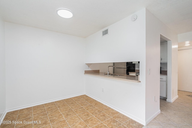 128 San Paulo Cir Unit 128, West Melbourne, FL 32904 - kitchen featuring freestanding refrigerator, light countertops, and light tile patterned floors