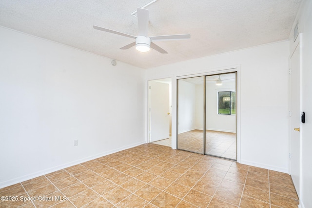 128 San Paulo Cir Unit 128, West Melbourne, FL 32904 - unfurnished bedroom featuring a textured ceiling, light tile patterned flooring, a closet, and a ceiling fan