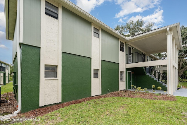 2219 Flower Tree Cir, Melbourne, FL 32935 - view of property exterior with stairway, a yard, and stucco siding