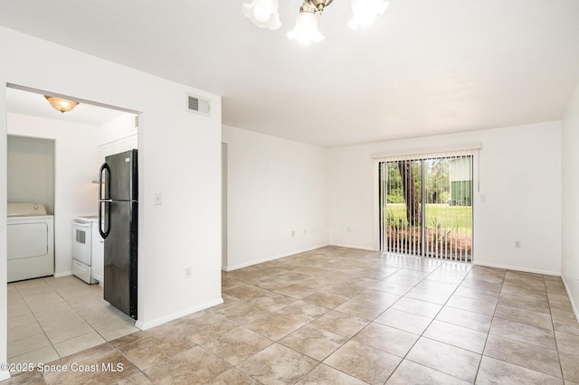 2219 Flower Tree Cir, Melbourne, FL 32935 - empty room featuring washer / dryer and a chandelier