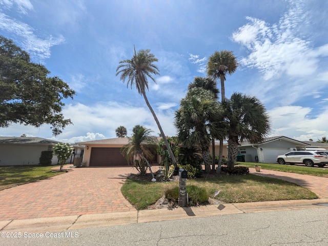 63 Yacht Haven Dr, Cocoa Beach, FL 32931 - ranch-style home featuring decorative driveway, an attached garage, a front lawn, and stucco siding