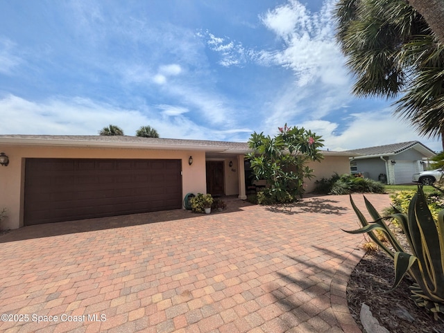 63 Yacht Haven Dr, Cocoa Beach, FL 32931 - view of front of home with stucco siding, decorative driveway, and an attached garage