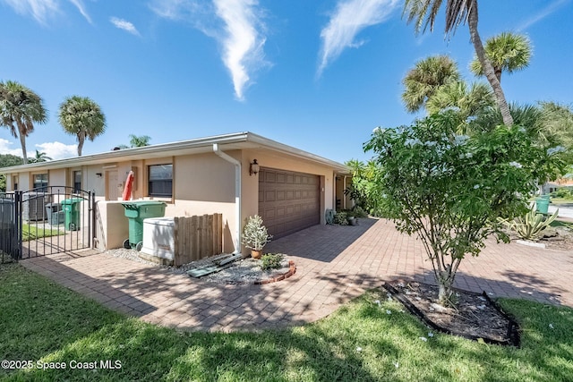 63 Yacht Haven Dr, Cocoa Beach, FL 32931 - view of front of house with stucco siding, a garage, a gate, and driveway