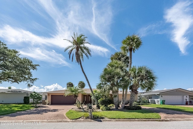 63 Yacht Haven Dr, Cocoa Beach, FL 32931 - view of front of property with decorative driveway, an attached garage, stucco siding, and a front lawn