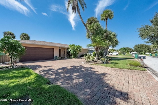63 Yacht Haven Dr, Cocoa Beach, FL 32931 - view of front of home featuring stucco siding, a garage, decorative driveway, and a front yard