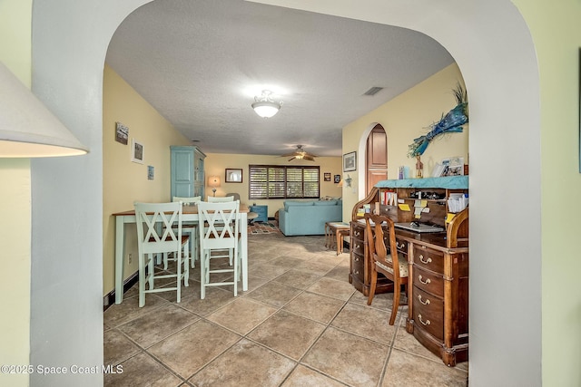 63 Yacht Haven Dr, Cocoa Beach, FL 32931 - dining area featuring arched walkways, a textured ceiling, and a ceiling fan